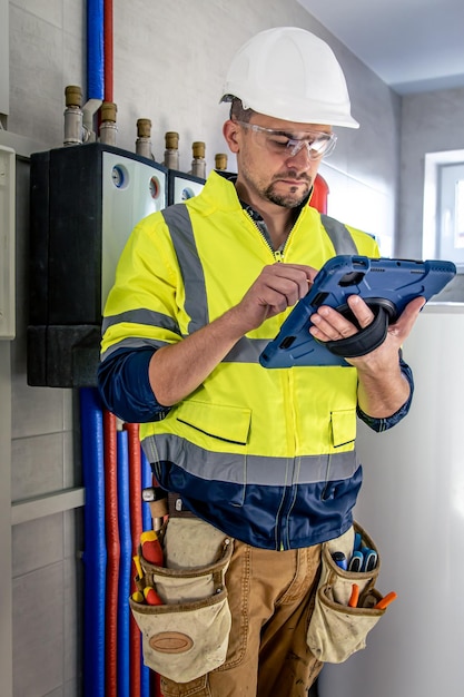 Free Photo man an electrical technician working in a switchboard with fuses uses a tablet