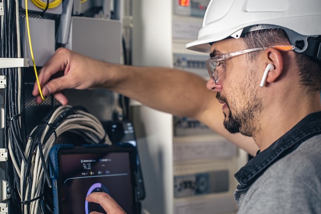 Free photo man an electrical technician working in a switchboard with fuses