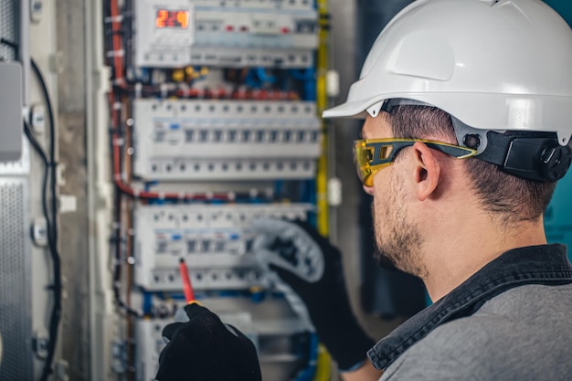 Free Photo man an electrical technician working in a switchboard with fuses