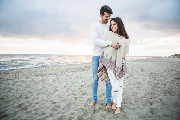 Man embracing his girlfriend on the beach