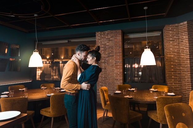 Man embracing with woman in restaurant