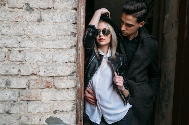 Free photo man embracing woman leaning on a door frame