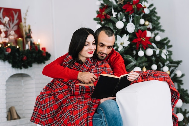 Man embracing woman with book