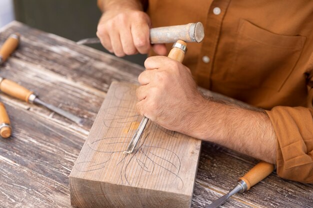 Man engraving in wood outdoors