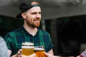 Free photo man enjoying alcoholic drink with his friends