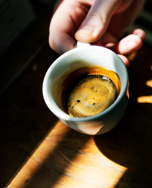 Free photo man enjoying a cup of hot coffee at a cafe