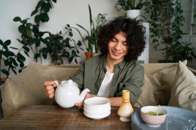 Free photo man enjoying a cup of matcha tea