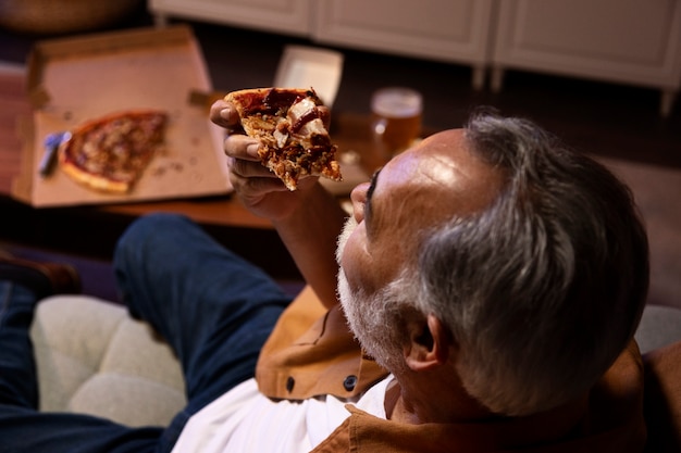 Man enjoying a pizza while being home alone