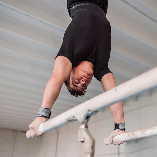 Free photo man exercising on parallel bars