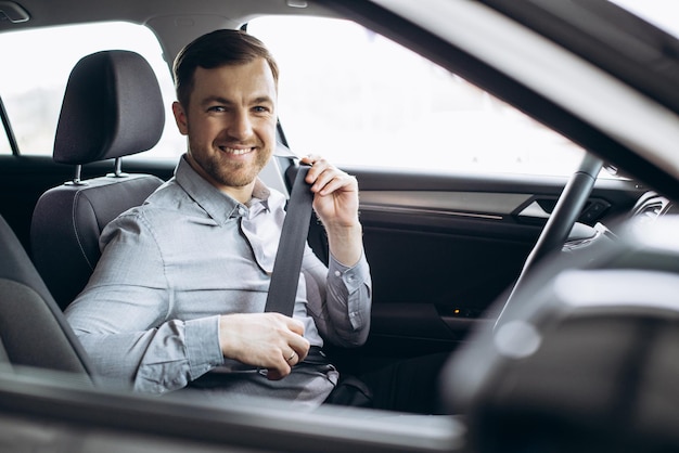 Man fastening safety belt in a car