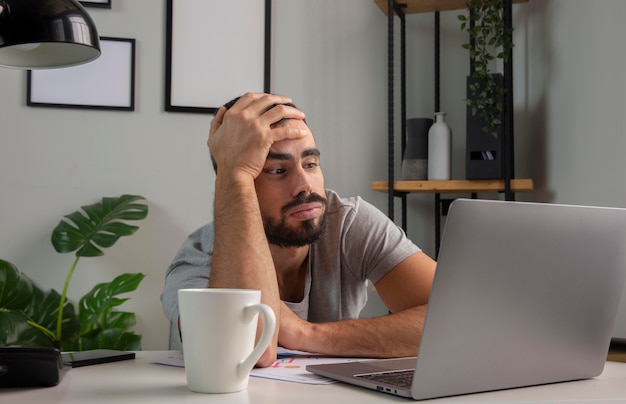 Man feeling bored while working from home