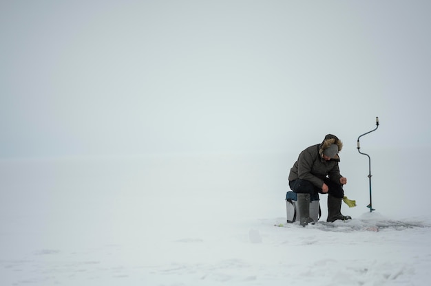 Free photo man fishing alone outside in winter