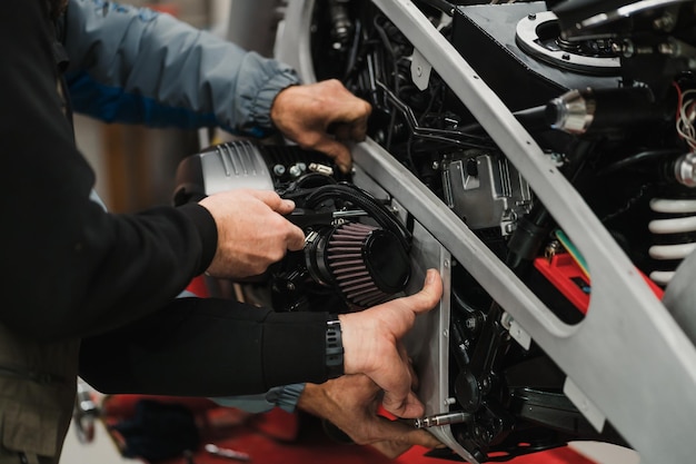 Man fixing a motorcycle in a modern workshop