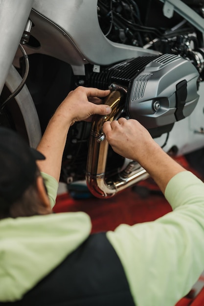 Man fixing a motorcycle in a modern workshop