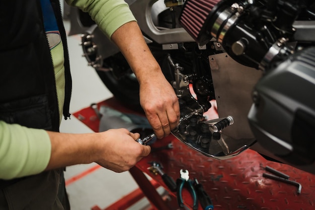 Man fixing a motorcycle in a modern workshop