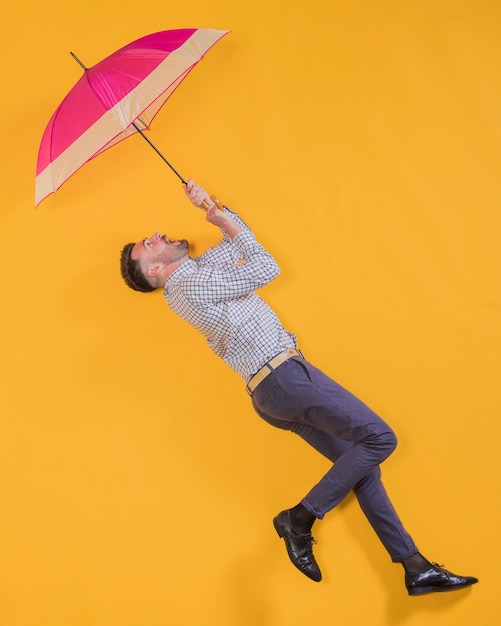 Free Photo man floating in the air with an umbrella