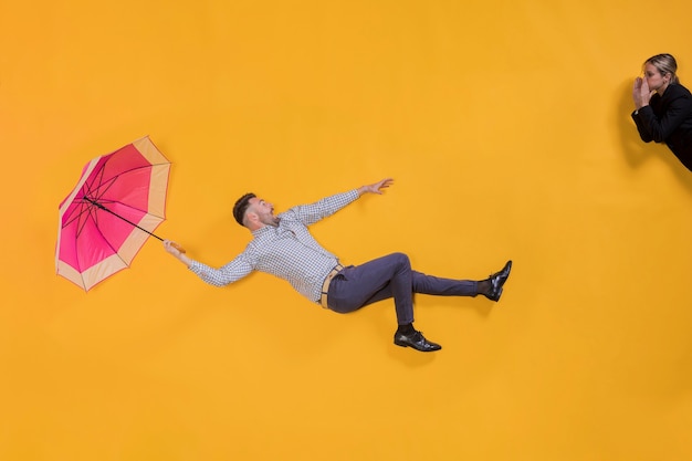 Free photo man floating in the air with an umbrella