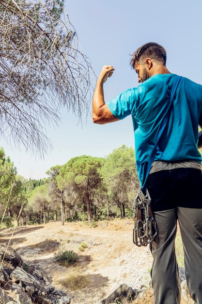 Man in forest showing biceps