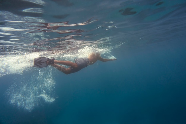 Man freediving with flippers underwater