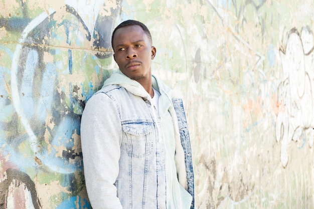 Free photo man in front of concrete wall