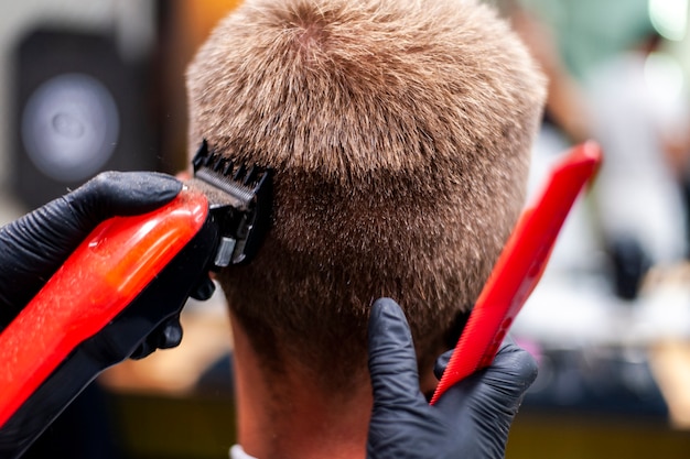 Free photo man getting a haircut with red trimmer