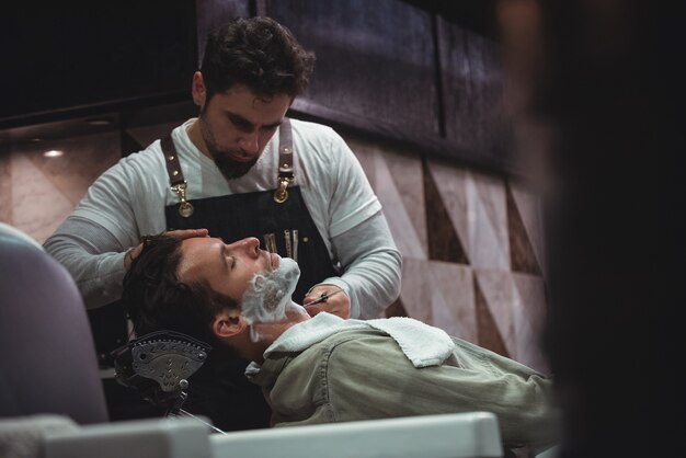 Man getting his beard shaved with razor