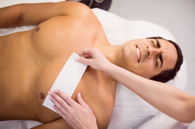 Man getting his chest waxed with wax strip