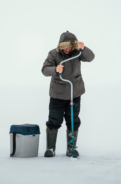 Man getting ready for fishing in frozen lake