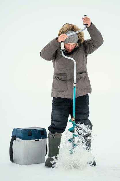 Man getting ready for fishing in frozen lake