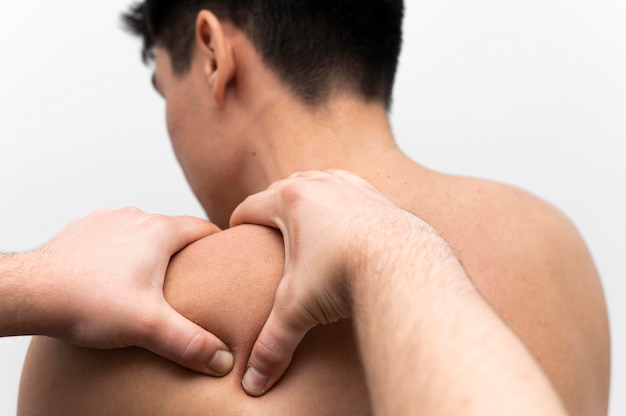 Man getting shoulder massage for pain from physiotherapist