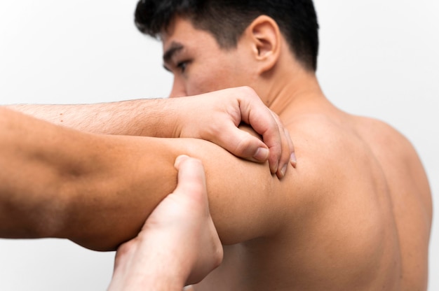 Man getting shoulder pain massage from physiotherapist