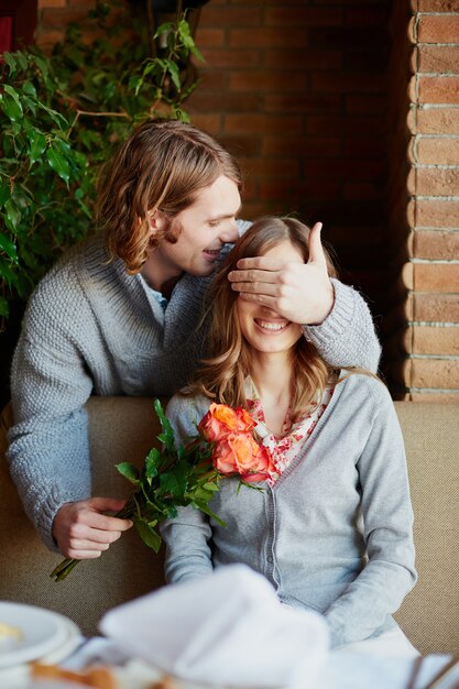 Free photo man giving a bouquet and a kiss to his wife