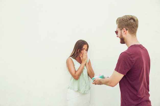 Free photo man giving gift to his surprised girlfriend