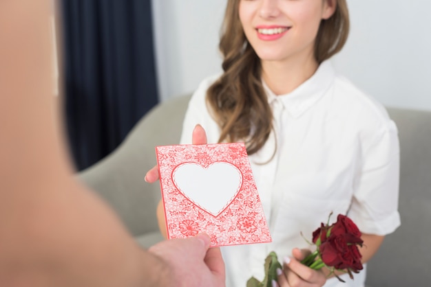 Free Photo man giving pink greeting card to woman 