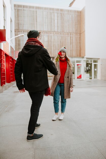 Man giving rose to girlfriend on street