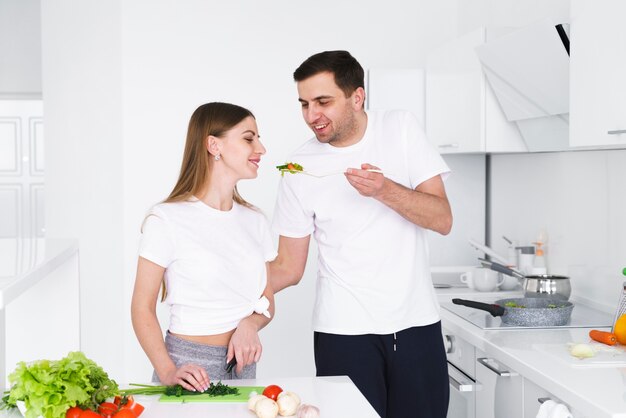 Man giving woman to taste