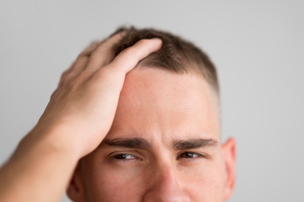 Free photo man gliding his fingers through his hair