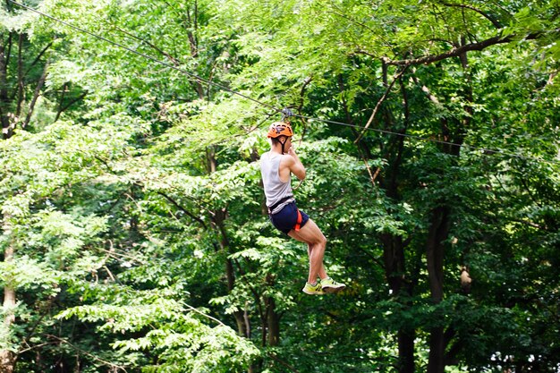 Man goes down on the rope in an entertainment park