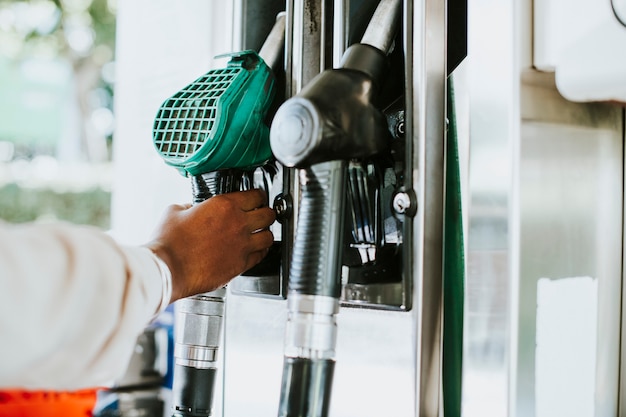 Free photo man grabbing a fuel nozzle to refuel his vehicle