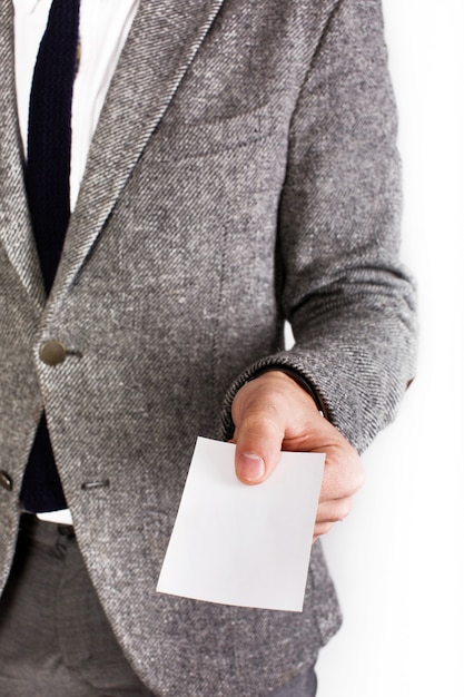 Man in grey business suit holds white card in his arm