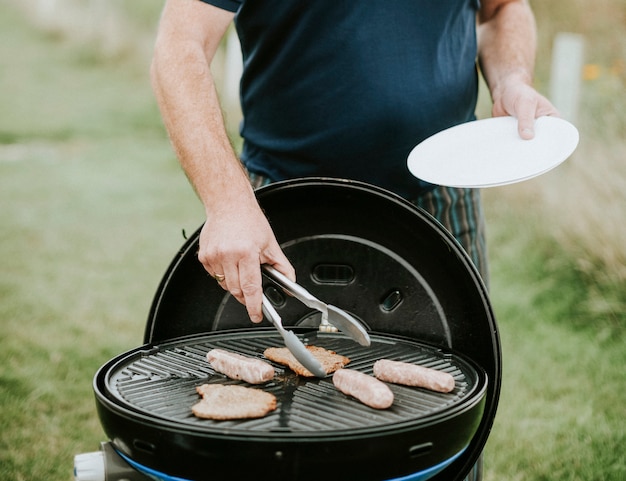 Free Photo man grilling meat sausages outdoor