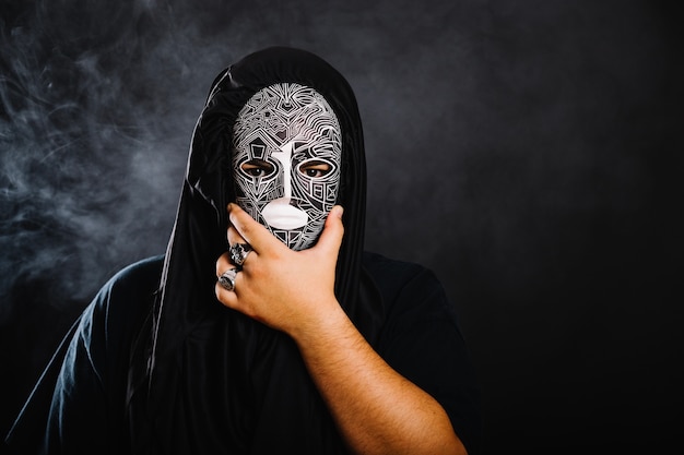 Free photo man in halloween mask covering face