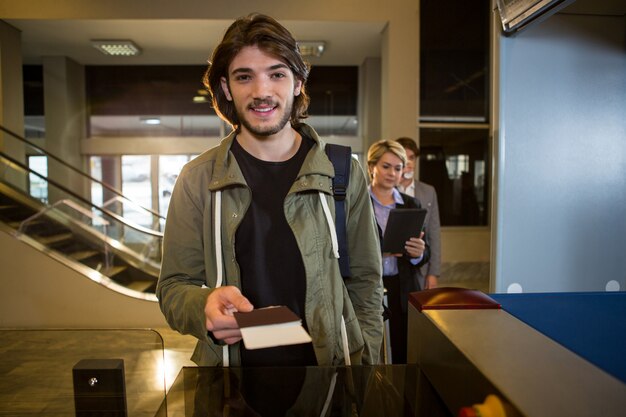 Man handing over his boarding pass at counter