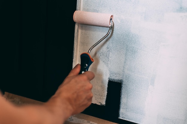 Man hands painting with a roller