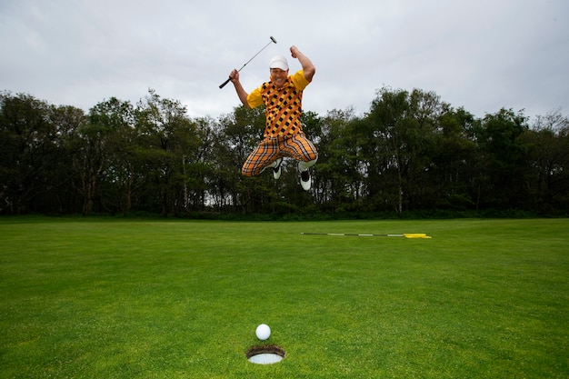 Free photo man having a game of golf outdoors on the course