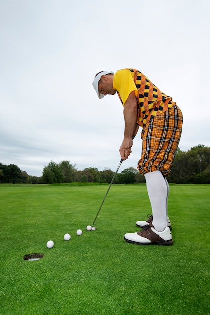 Free photo man having a game of golf outdoors on the course