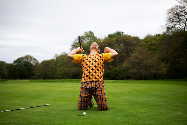 Free photo man having a game of golf outdoors