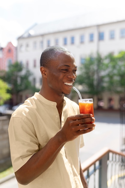 Man having an iced coffee break outdoors