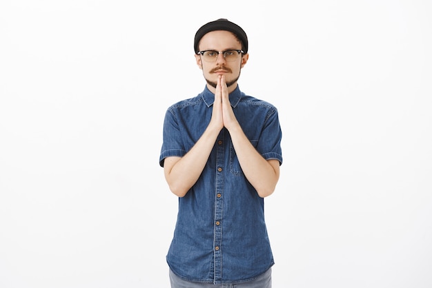 Free photo man having serious expression in pray gesture