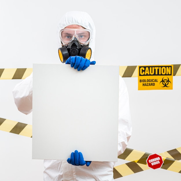 Man in hazmat suit with a blank sign